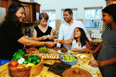 cheerful Hispanic family cooking dinner.